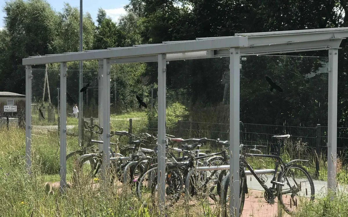 Bicicletas aparcadas bajo una marquesina junto a un apeadero de tren