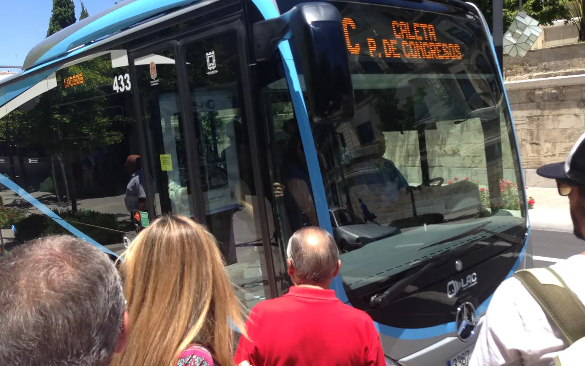 Personas subiendo a un autobús urbano en una parada de Granada
