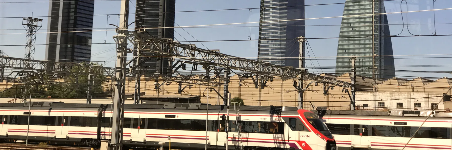 Un tren de Cercanías de Renfe pasando ante las cuatro torres de Madrid