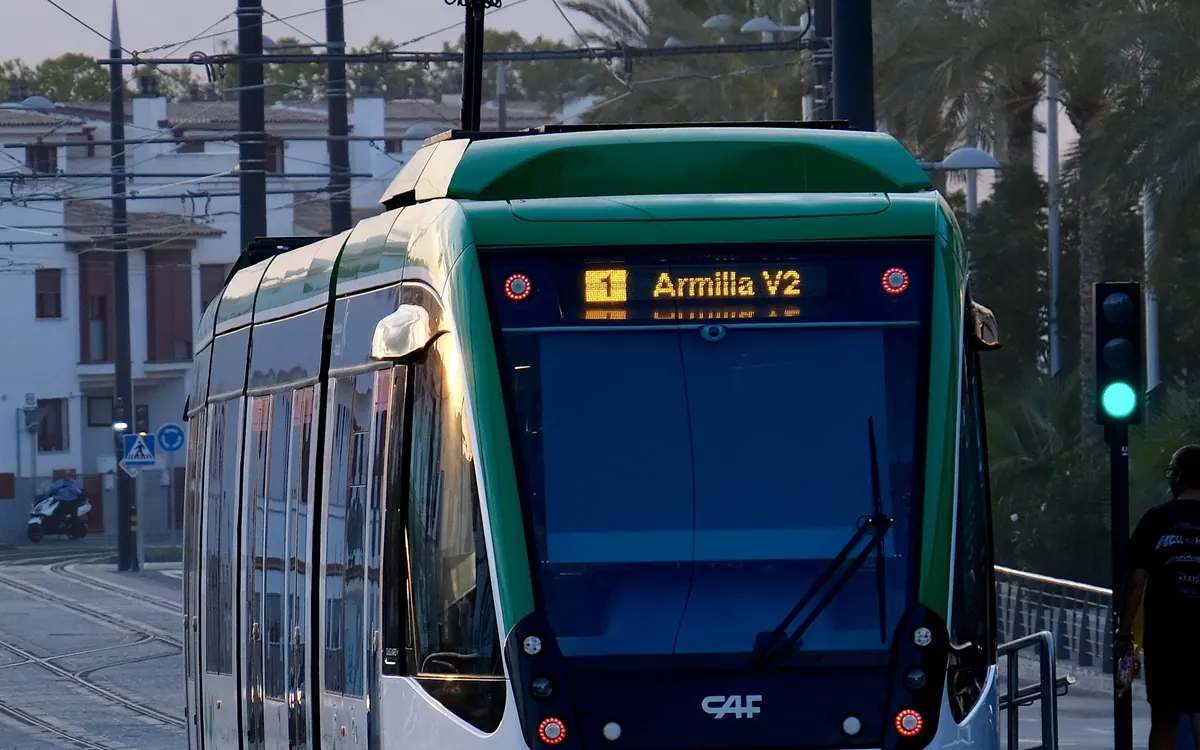 Tranvía del Metropolitano de Granada circulando por la calle al atardecer